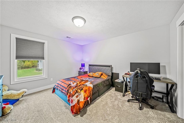 bedroom featuring visible vents, carpet flooring, a textured ceiling, and baseboards