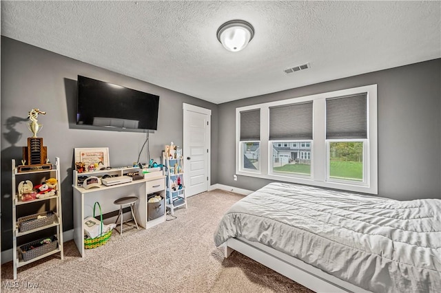 bedroom with visible vents, baseboards, a textured ceiling, and carpet flooring