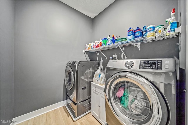 laundry room with washer and dryer, light wood-type flooring, baseboards, and laundry area