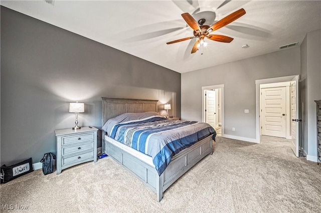 carpeted bedroom featuring visible vents, baseboards, ceiling fan, and ensuite bathroom