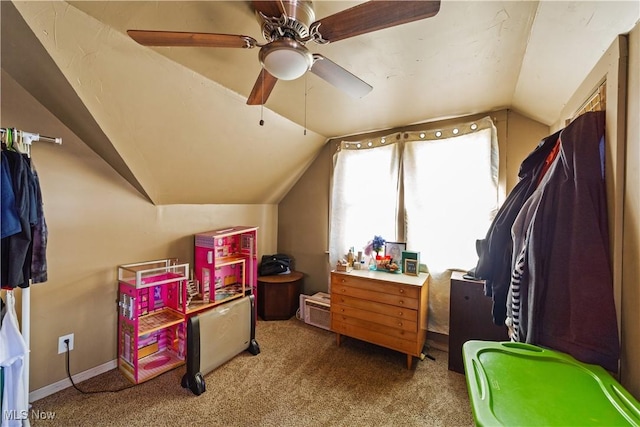 recreation room featuring a ceiling fan, vaulted ceiling, carpet, and baseboards