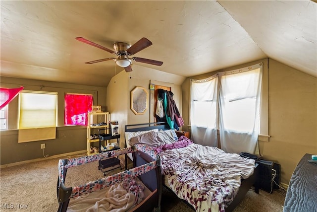 carpeted bedroom with vaulted ceiling, baseboards, and ceiling fan