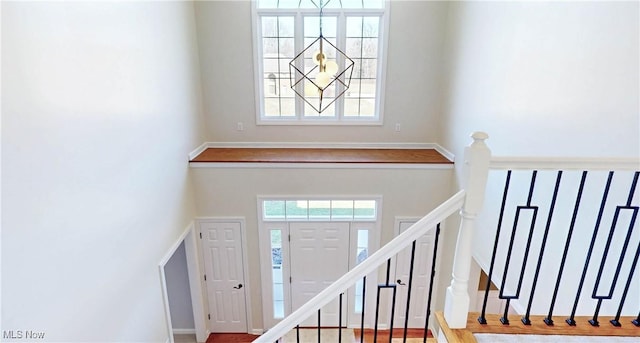 foyer entrance with stairway, a high ceiling, and a wealth of natural light