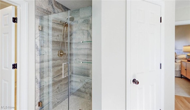 bathroom featuring a shower stall, wood finished floors, and ensuite bathroom