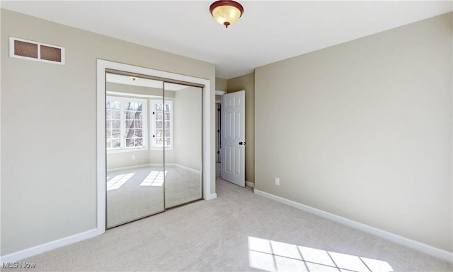 unfurnished bedroom featuring a closet, baseboards, visible vents, and carpet floors