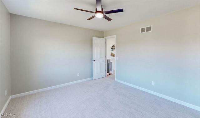 empty room with a ceiling fan, baseboards, visible vents, and light carpet