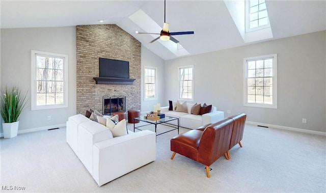 carpeted living area with a brick fireplace, a skylight, visible vents, and ceiling fan