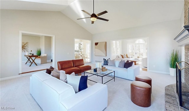 carpeted living area with high vaulted ceiling, a fireplace, baseboards, and ceiling fan