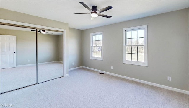 unfurnished bedroom featuring visible vents, carpet, baseboards, and a closet