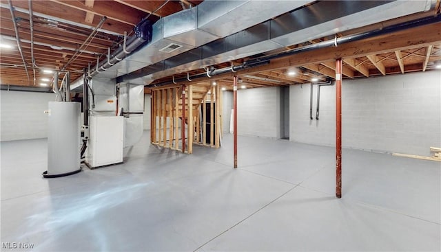 unfinished basement with heating unit, visible vents, and water heater