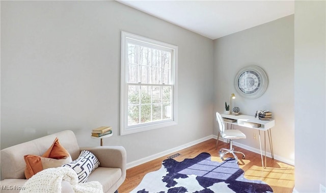 home office with baseboards and wood finished floors