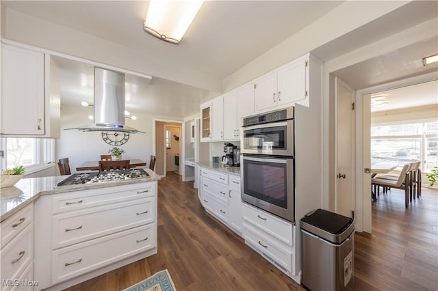 kitchen with a healthy amount of sunlight, white cabinets, stainless steel appliances, and island range hood