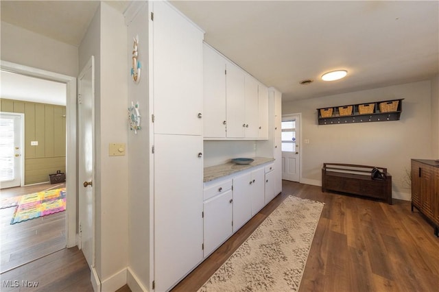 kitchen featuring white cabinets, baseboards, and wood finished floors