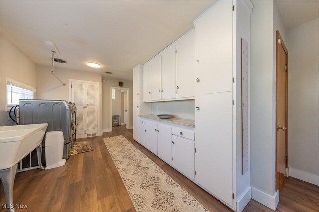 laundry room with wood finished floors and baseboards