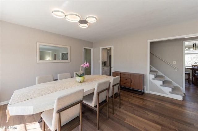 dining area with stairway, baseboards, and dark wood-style floors