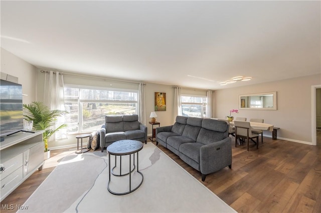 living area featuring baseboards and dark wood-style floors