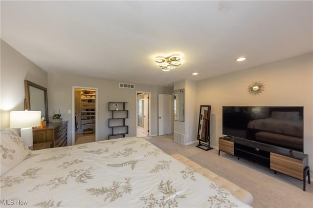 bedroom featuring carpet, visible vents, recessed lighting, a closet, and a walk in closet