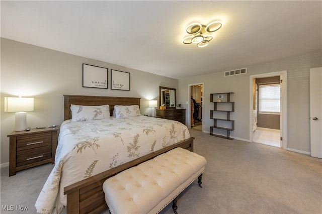 carpeted bedroom featuring baseboards, visible vents, a spacious closet, a closet, and connected bathroom