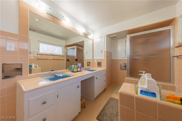 bathroom with an enclosed shower, tile walls, and vanity