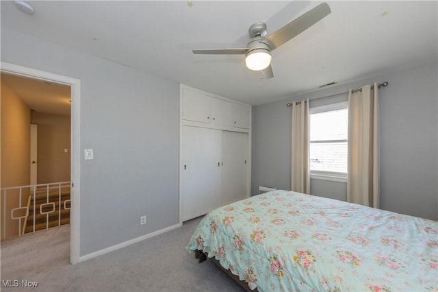 bedroom with a closet, baseboards, a ceiling fan, and carpet flooring