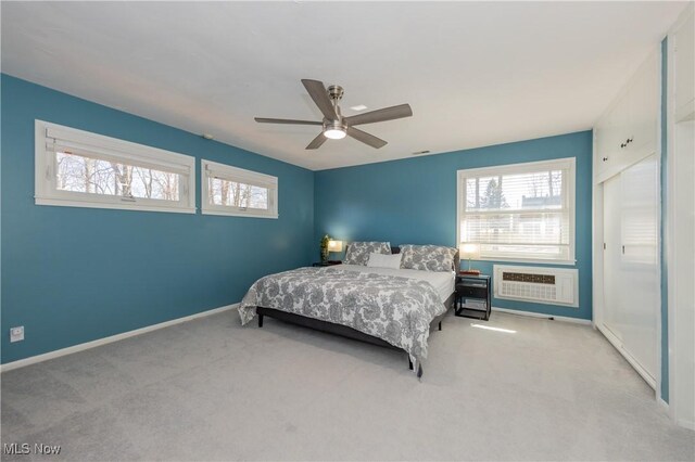 bedroom with multiple windows, a wall unit AC, and carpet floors