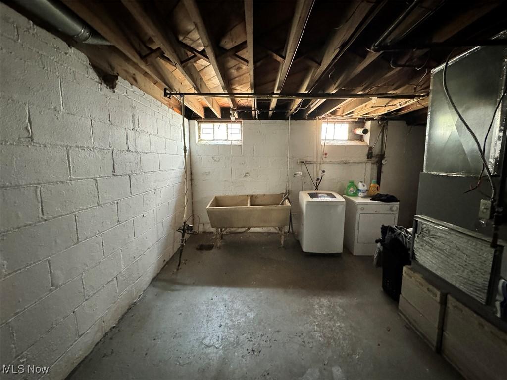 basement with washing machine and clothes dryer and a sink