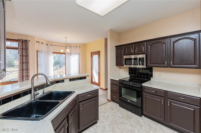 kitchen featuring stainless steel microwave, black range with electric cooktop, light countertops, and a sink