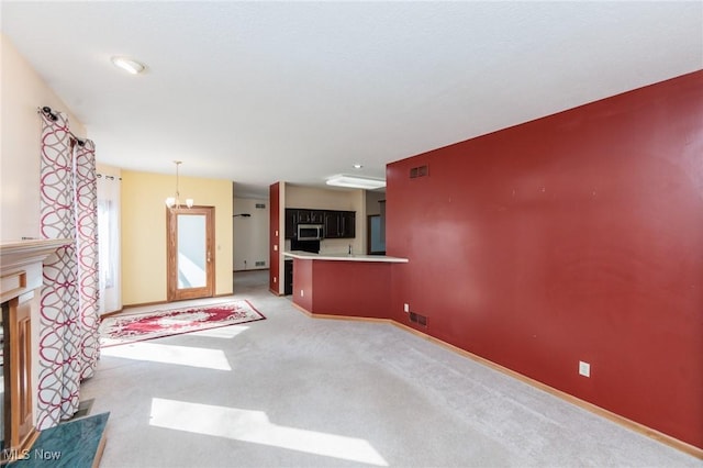 unfurnished living room featuring visible vents, light colored carpet, a fireplace, and baseboards