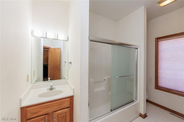 bathroom with toilet, an enclosed shower, vanity, and baseboards