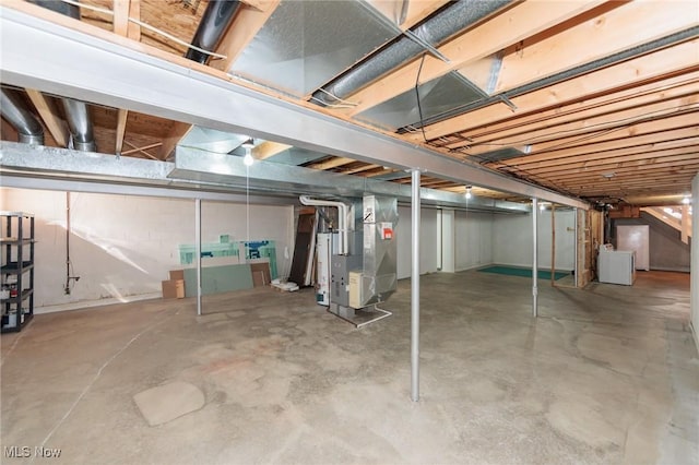 unfinished basement with heating unit and washer / dryer