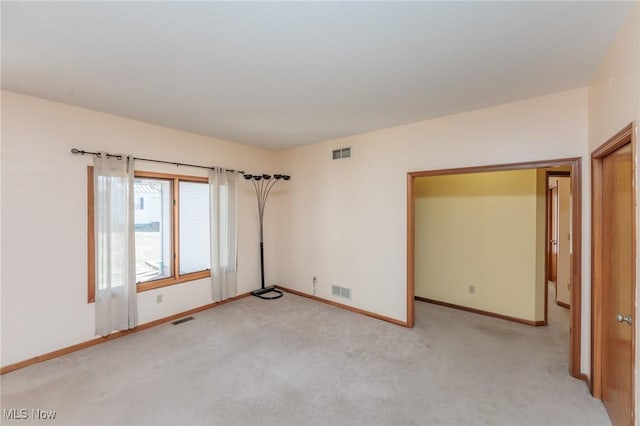 unfurnished room featuring light colored carpet and visible vents