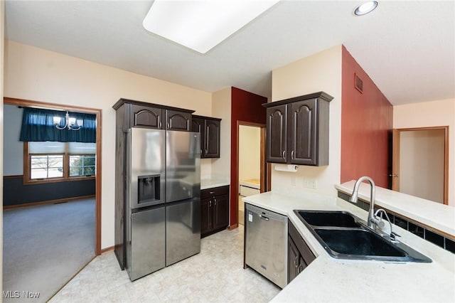 kitchen with a sink, stainless steel appliances, dark brown cabinetry, and light countertops