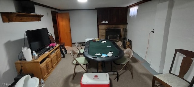 recreation room with a fireplace with raised hearth