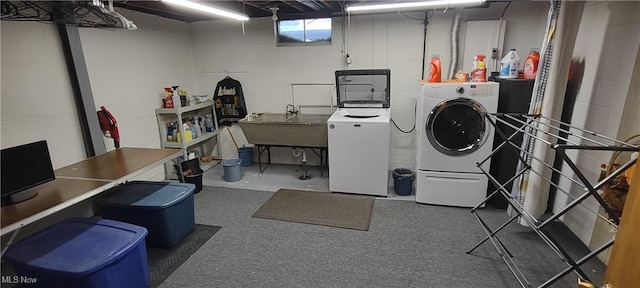 laundry area featuring washing machine and clothes dryer, laundry area, and a sink