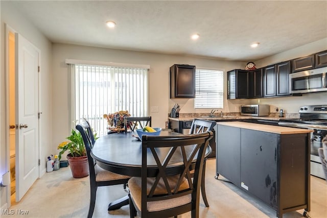 kitchen featuring a kitchen island, recessed lighting, stainless steel appliances, and a sink