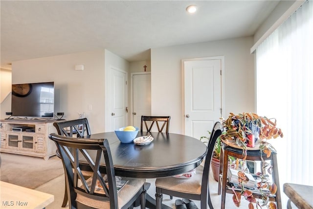 dining area featuring plenty of natural light and light colored carpet