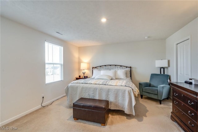 bedroom with light carpet, visible vents, and baseboards