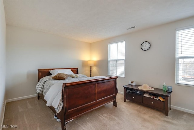 bedroom featuring light carpet, visible vents, and baseboards