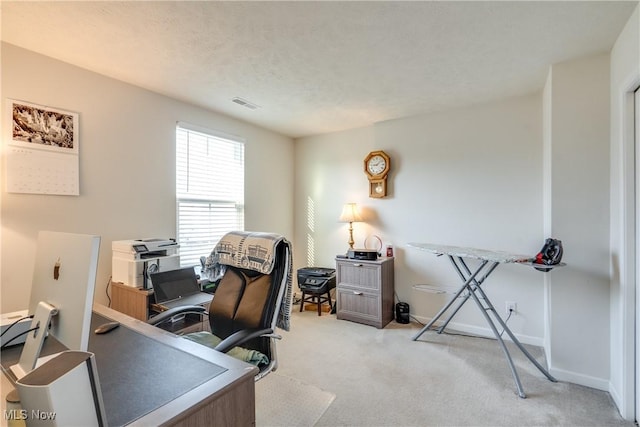 carpeted office with visible vents, a textured ceiling, and baseboards