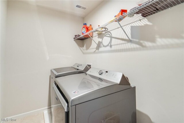 laundry room with laundry area, baseboards, visible vents, and washer and clothes dryer