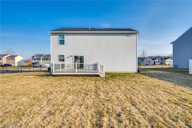 back of house with a yard, a residential view, a wooden deck, and fence