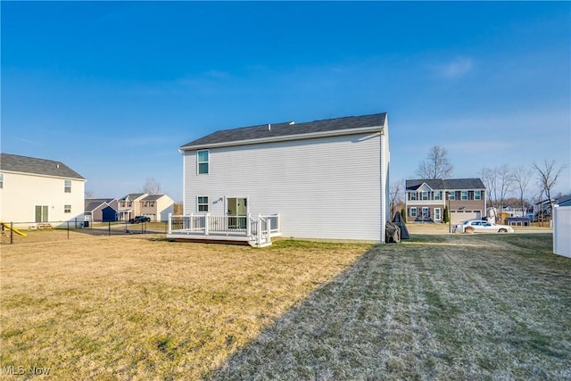 back of property with a residential view, a wooden deck, a yard, and fence