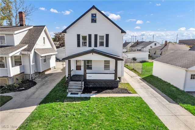 view of front of house with a residential view, a porch, a front lawn, and fence