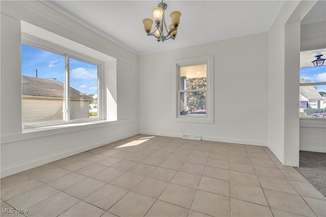 unfurnished dining area featuring light tile patterned floors, visible vents, and an inviting chandelier