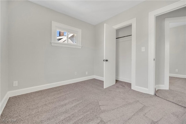 unfurnished bedroom with a closet, baseboards, and carpet flooring