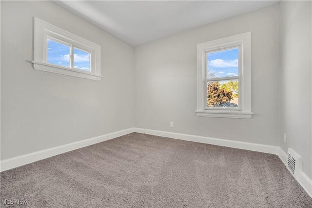 carpeted empty room featuring visible vents and baseboards