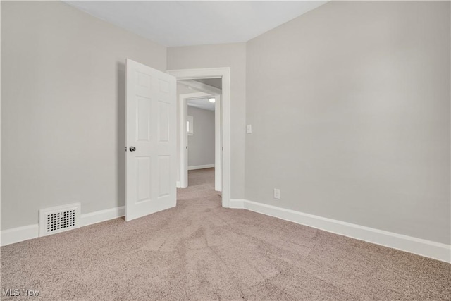 carpeted empty room featuring visible vents and baseboards