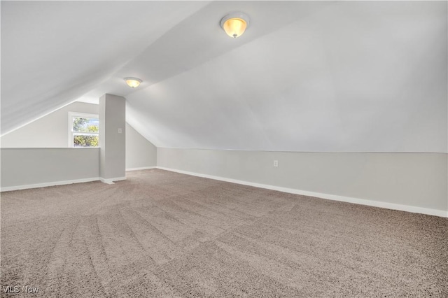 additional living space featuring baseboards, carpet floors, and vaulted ceiling