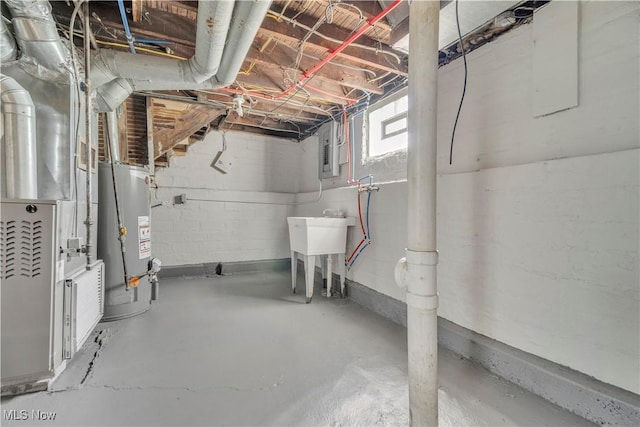 basement featuring gas water heater, electric panel, and a sink