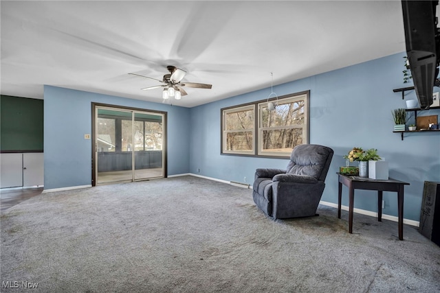 sitting room with baseboards, carpet floors, and ceiling fan